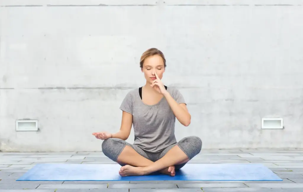 Young girl doing nostril breathing exercise or pranayama yoga in Salt Lake City, UT | Santosh Yoga Institute