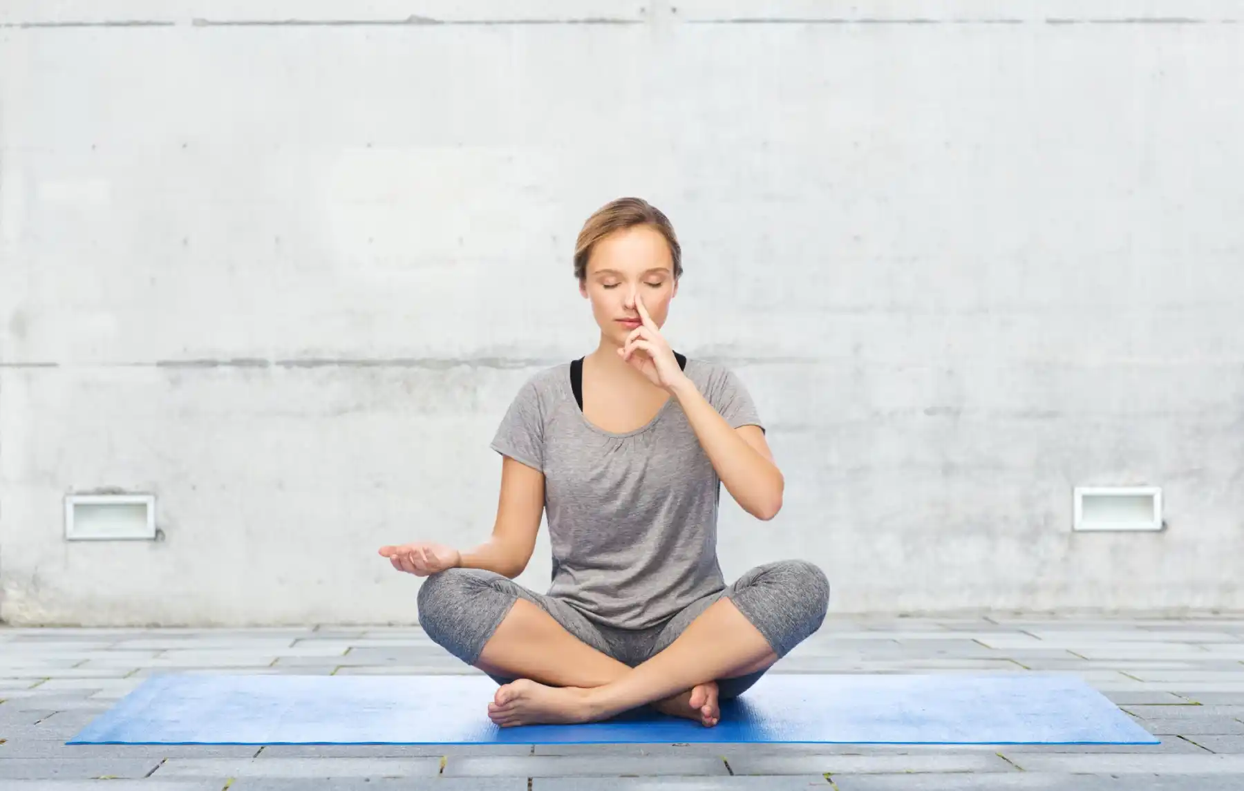 Young girl doing nostril breathing exercise or pranayama yoga in Salt Lake City, UT | Santosh Yoga Institute