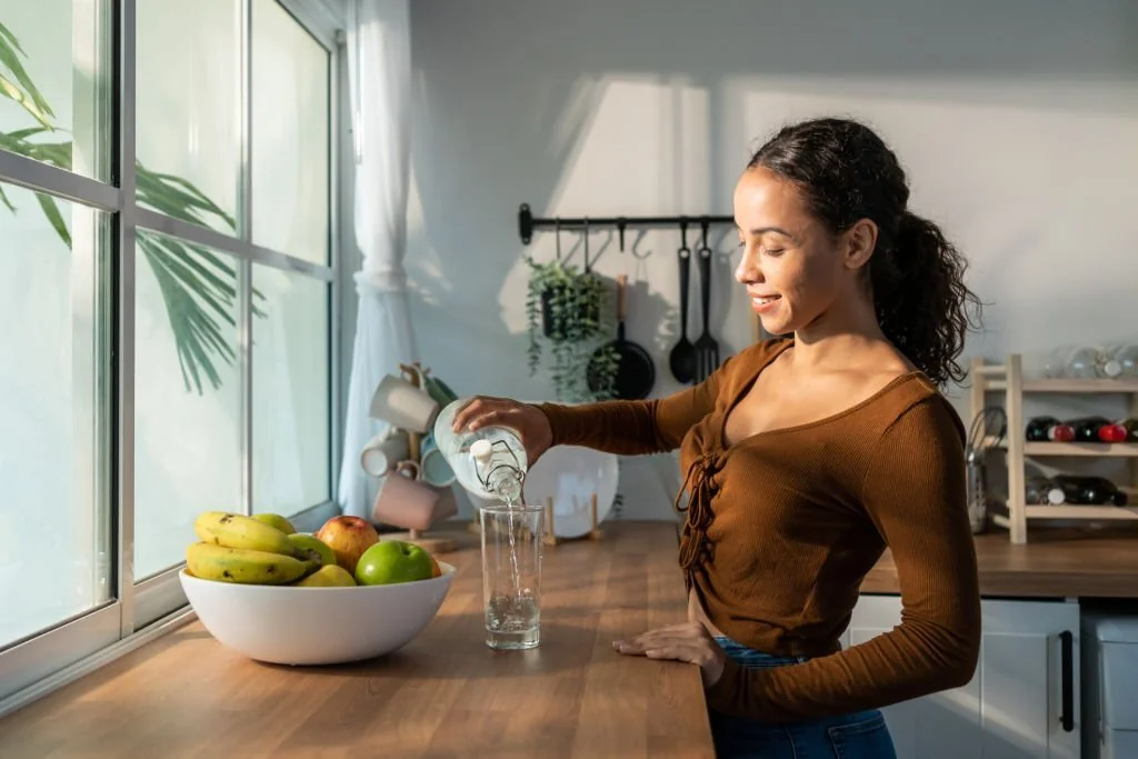 Young girl pouring a glass of water in Salt Lake City, UT | Santosh Yoga Institute