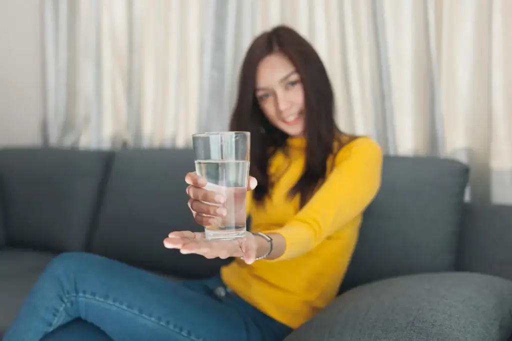 Young girl holding glass of water in hands in Salt Lake City, UT | Santosh Yoga Institute